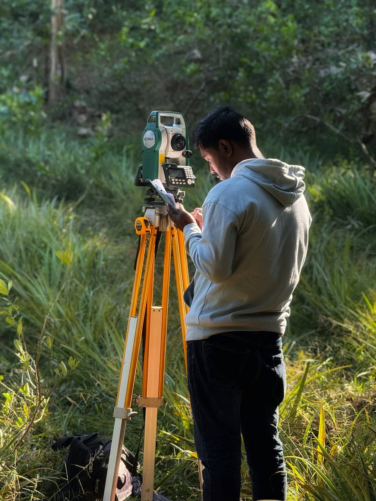 Surveyor operating a total station in the field