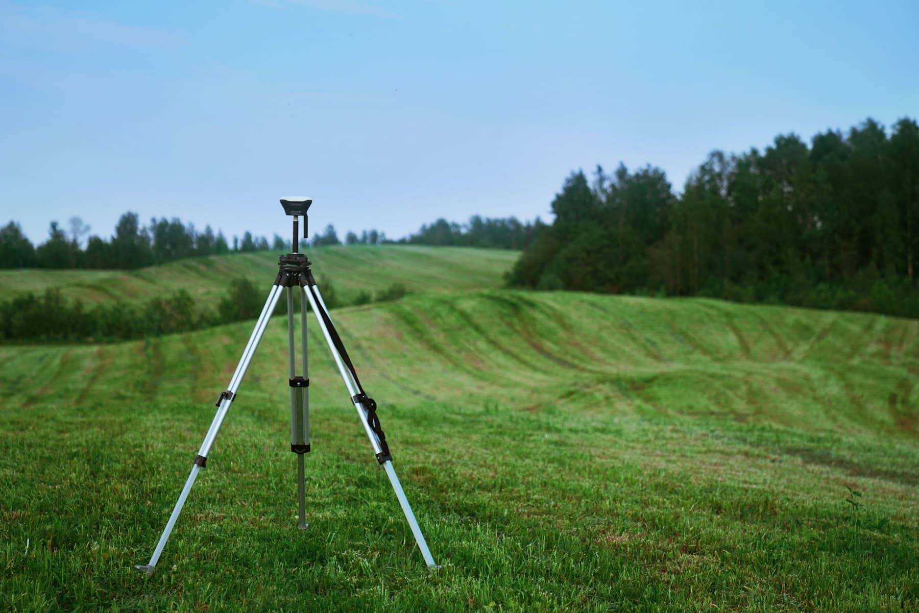 GNSS receiver on a tripod in a rural area